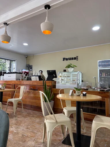 Interior acogedor de Pausa Café con madera, plantas y luz cálida
